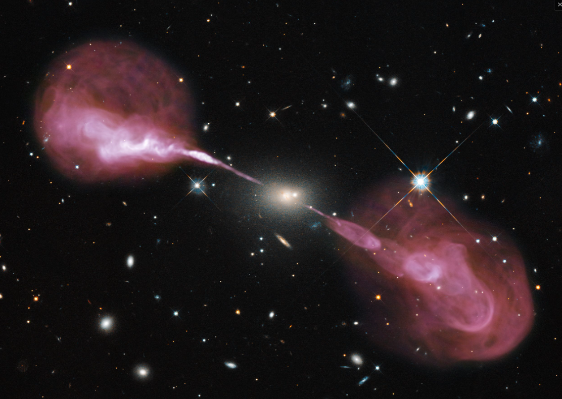 A composite image of the radio galaxy Hercules A, with the radio image obtained by Vla (New Mexico, USA) superimposed on the field photographed in optical by the orbiting Hubble Space Telescope. The optical image of the host galaxy is clearly visible in the center, and the two collimated radio jets emerging from the nuclear region. Blazars are sources of this type but fortuitously oriented with the axis of the relativistic jet in a direction close, within a few degrees, to the line of sight. Credits: NASA, ESA, S. Baum and C. O’Dea (RIT), R. Perley and W. Cotton (NRAO/ AUI/ NSF), and the Hubble Heritage Team (STSCI/AURA)