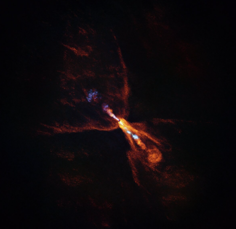 Questa è HOPS-315, una stella neonata in cui gli astronomi hanno osservato prove delle prime fasi della formazione planetaria. L'immagine è stata scattata con l'Atacama Large Millimeter/submillimeter Array (ALMA), di cui l'ESO è partner. Insieme ai dati del James Webb Space Telescope (JWST), queste osservazioni mostrano che i minerali caldi stanno iniziando a solidificarsi. In arancione vediamo la distribuzione del monossido di carbonio, che si allontana dalla stella con un vento a forma di farfalla. In blu vediamo uno stretto getto di monossido di silicio, anch'esso irradiato dalla stella. Questi venti e getti gassosi sono comuni intorno a stelle neonate come HOPS-315. Insieme, le osservazioni di ALMA e JWST indicano che, oltre a queste caratteristiche, c'è anche un disco di monossido di silicio gassoso attorno alla stella che si sta condensando in silicati solidi – le prime fasi della formazione planetaria - Crediti: ALMA(ESO/NAOJ/NRAO)/M. McClure et al.