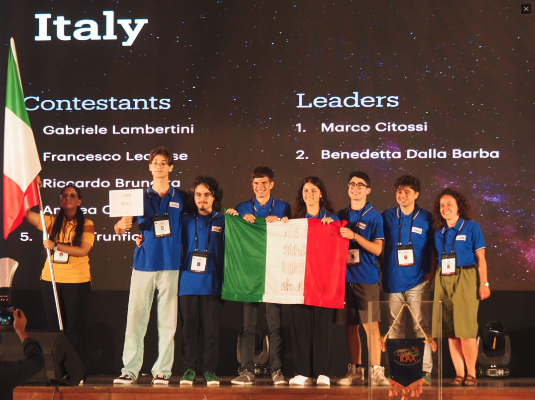 La squadra italiana sul palco alla cerimonia di apertura, accompagnata dai team leader. Da sinistra: Riccardo Brunetta, Francesco Leccese, Andrea Cusimano, Ilenia Trunfio, Gabriele Lambertini e i team leader Marco Citossi (INAF-Trieste) e Benedetta Dalla Barba (nostra dottoranda). Crediti: Marco Citossi/Inaf